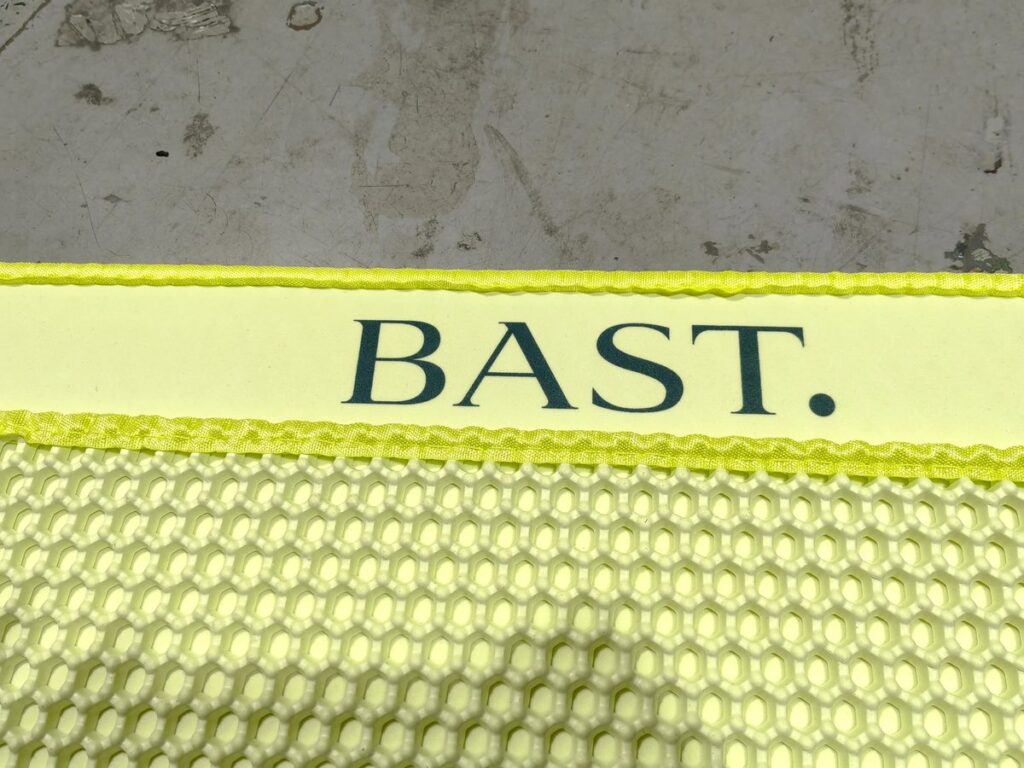 Logotipo BAST. en el borde de la alfombra