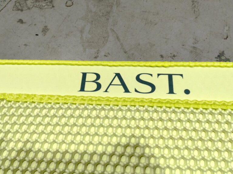 Logotipo BAST. en el borde de la alfombra